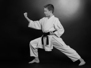 Young martial arts student practicing a strong stance, demonstrating focus and confidence.