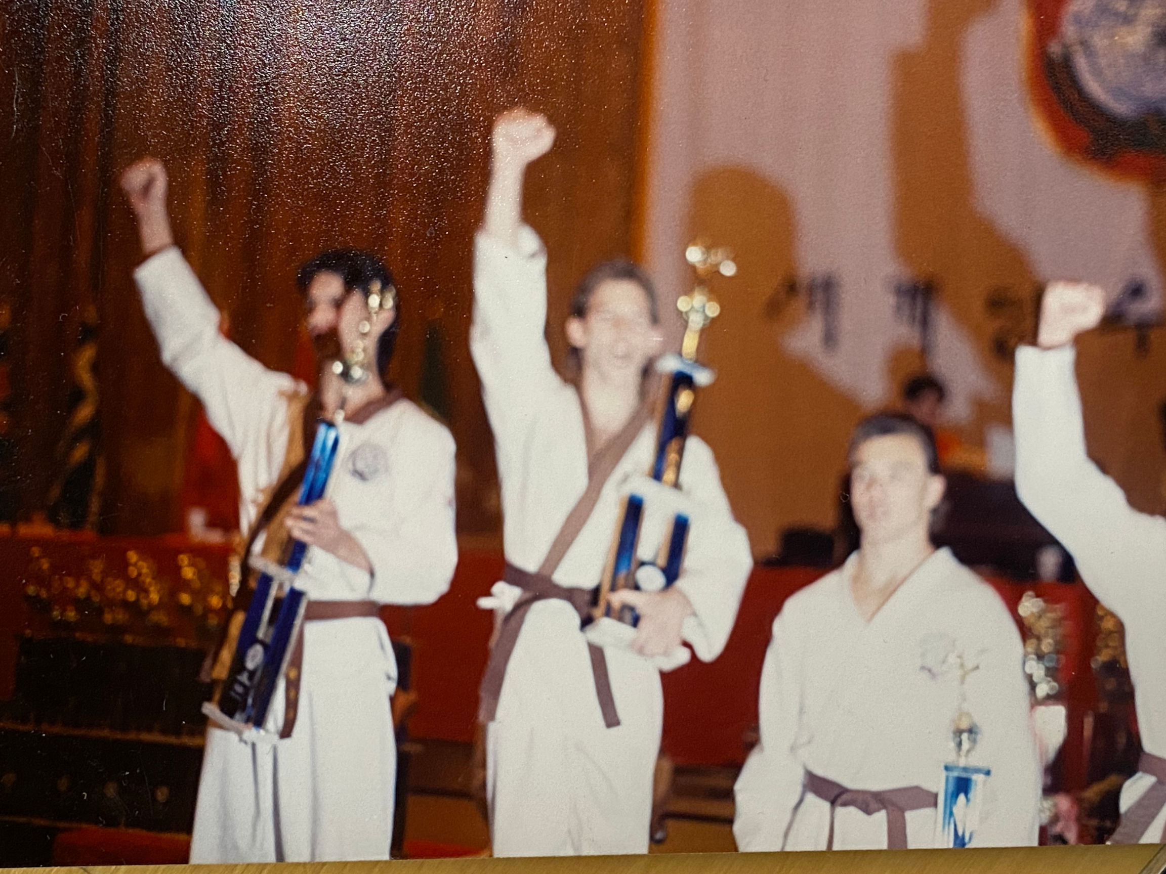 Dr. Salvatore Sandone celebrates winning the 1988 World Tang Soo Do Championships as an adult brown belt, holding a trophy alongside fellow competitors